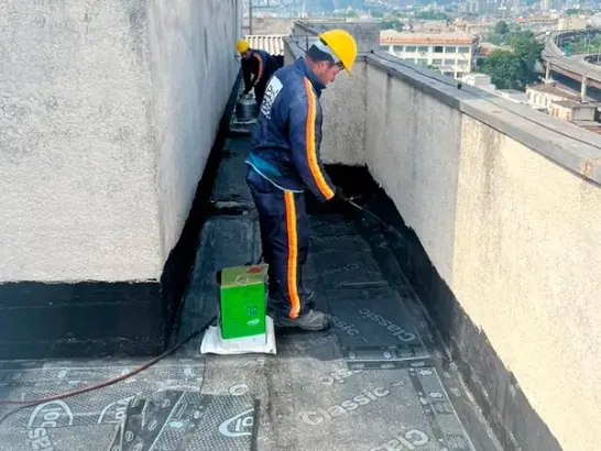 Profissional aplicando impermeabilização com maçarico em laje de cobertura no Rio de Janeiro